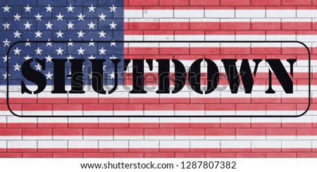 With the word "Shutdown" on flag of united states of america painted over on brick wall.