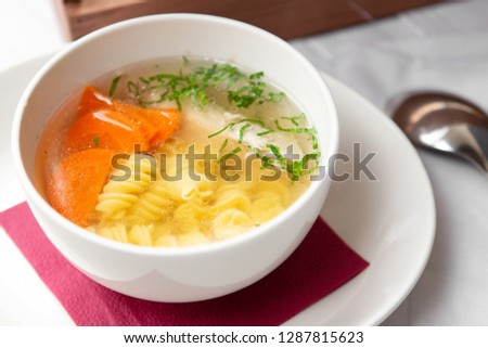 Chicken soup with pasta fusilli in the bowl on the wood table Royalty-Free Stock Photo #1287815623