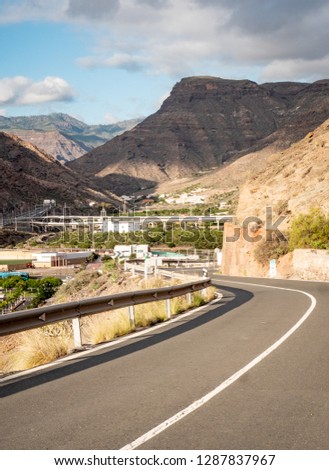 An open road leading into the rocky volcanic mountains found on the Canary Island of Gran Canaria.