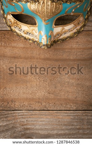 Decorated venetian mask for mardi gras on wooden table