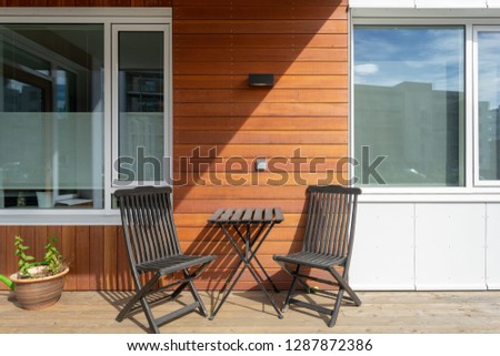 Close up photo of empty terrace with wooden furniture chair and table in modern house
