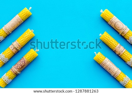 Buddhism. Candles with Yantras and mantras in sanskrit on blue background top view pattern copy space