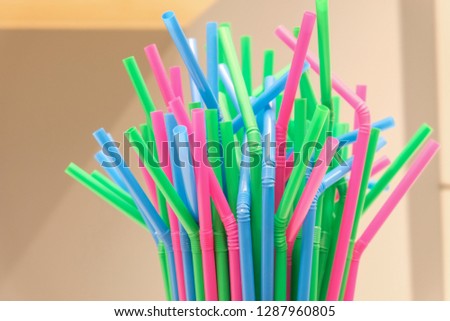 Top of several drinking straws made of plastic with different colors with blurred background