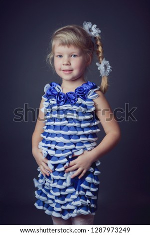 Studio photo of beautiful little girl with long blond hair.
