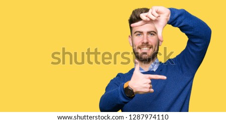 Young handsome bussines man smiling making frame with hands and fingers with happy face. Creativity and photography concept.