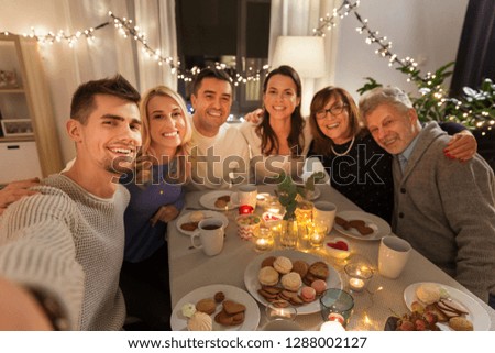 celebration, holidays and people concept - happy family having tea party at home and taking selfie