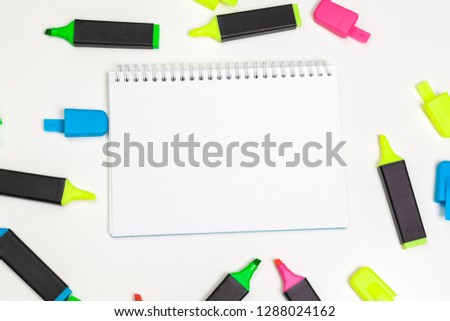 highlighters and  blank notepad paper sheet flat lay on a desk 