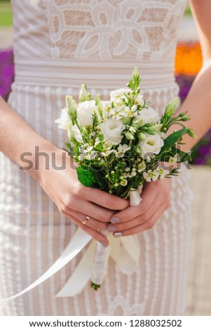 Bride is holding beautiful bright wedding bouquet