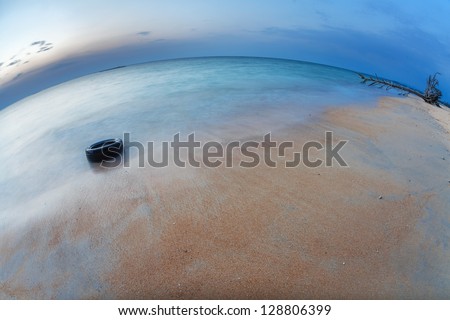 Before night on the white sand tropical beach with tire. Phuket. Thailand