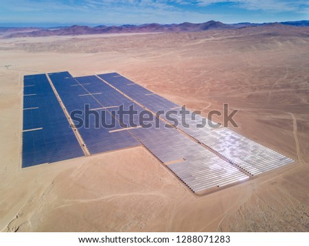 An aerial drone view of a Solar Energy Photovoltaic PV Plant over the Atacama desert in Chile, trying to get the energy from the sun with Solar Energy in the driest desert in the world: Atacama
