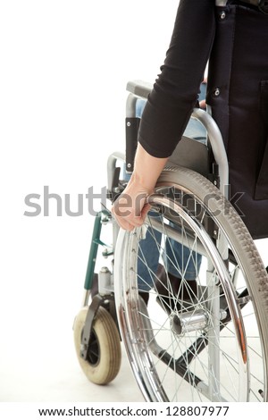 hands of a young woman sitting on a wheelchair, white background Royalty-Free Stock Photo #128807977