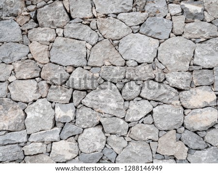 Dry Stone Wall. The random pattern of a flat dry wall stone wall. Full frame abstract background texture.
