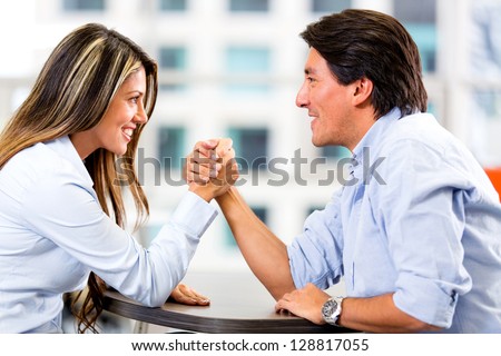 Business couple  arm wrestling at the office