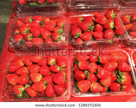 Strawberries are on a red table.