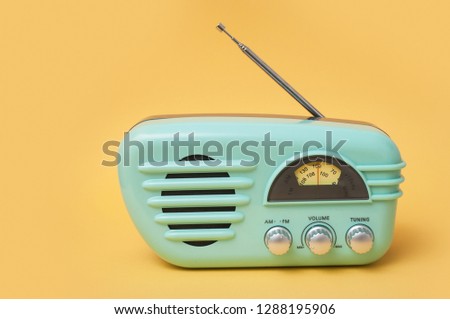 closeup of vintage fifties style radio on yellow background