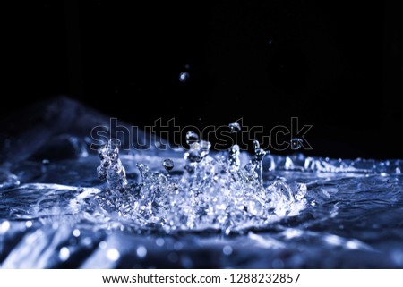 Water drops splashing on acoustic membrane. A lot of drops in air. High frequency of sound waves. Water cloud small drops. Frozen time shot. 