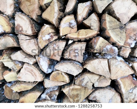 Firewood in winter. The texture of impaled wood in the snow