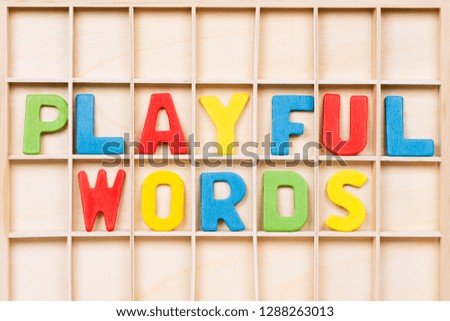 Playful words text from colorful wooden letters are on wooden background, education, learning english or mother language concept.