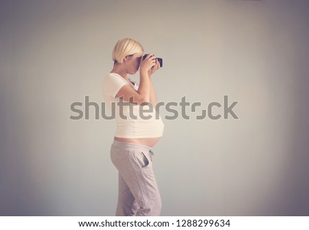 pregnant woman photographer with a film camera. toned