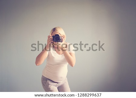 pregnant woman photographer with a film camera. toned