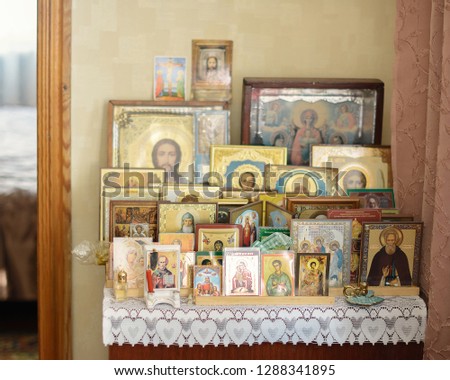 icons of saints are on the bedside table in the room