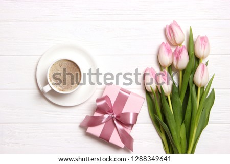 bouquet of beautiful tulips, gift and coffee on wooden background top view. Mother's Day Background, International Women's Day, Birthday. Holiday, give a gift.