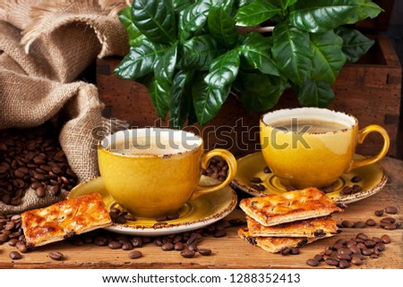 Still life with coffee cup,  cookies  and fresh leaves  on dark background