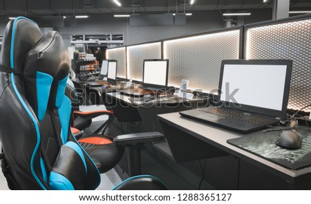 Gaming space with a chair and a laptop in a store technology. Professional equipment for cybersport. Buying a gaming laptop, headphones, mouse and armchairs. Gaming equipment concept. Royalty-Free Stock Photo #1288365127