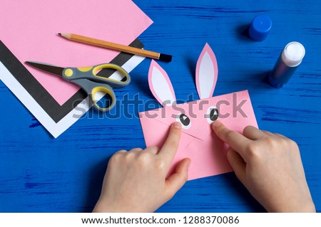 How to make envelope in form of bunny for Easter greetings. Children's art project. DIY concept. Step by step photo instruction. Step 9. Glue bunny eyes