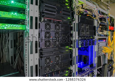 There are many telecommunications equipment in the racks of the data center server room. Powerful modern routers work on the technical site of the Internet provider.