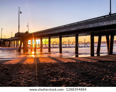 Sun sets over the pacific ocean in Marina del Rey and Venice Beach Pier