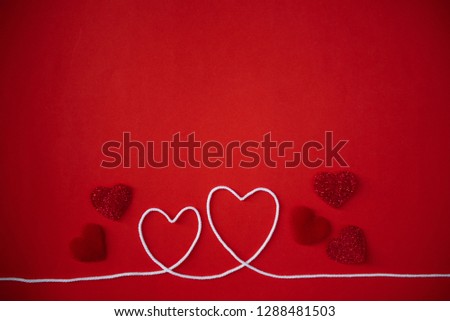 Heart shape from white rope on red paper background