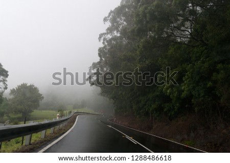Windy mountain road at fog. Road infrastructure. Dangerous driving conditions metaphor. Motion blur
