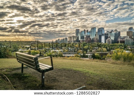 Beautiful sunrise in autumn morning over the Calgary downtown with bench in foreground, Canada