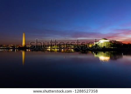 Washington DC panorama around Tidal Basin at dawn during cherry blossom in spring. Urban skyline with Thomas Jefferson Memorial and Washington Monument in US capital.