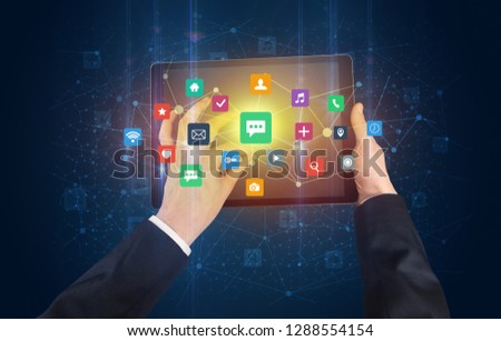 Hand using tablet with colorful bounce application symbols and icons concept