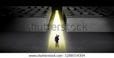 Businessman going straight ahead on a lighted carpet arrow between two maze