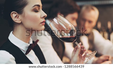 Experienced sommelier woman explores taste of wine in restaurant. Wine tasting. Checking taste, color, sediments of wine Royalty-Free Stock Photo #1288566439