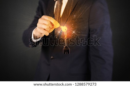 Formal man hand over shiny keys with dark background
