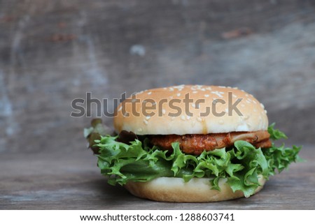 Chicken steak burger with fresh vegetable fastfood, American meal high calories put on wood background  