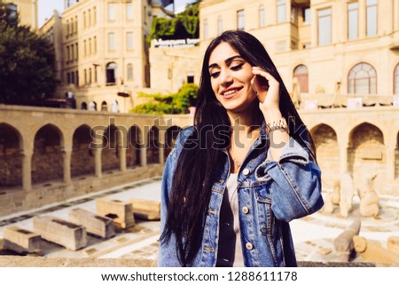happy beautiful woman speaks by phone on building background