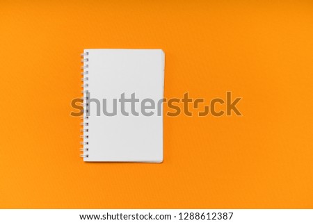 white notebook lies on an orange background