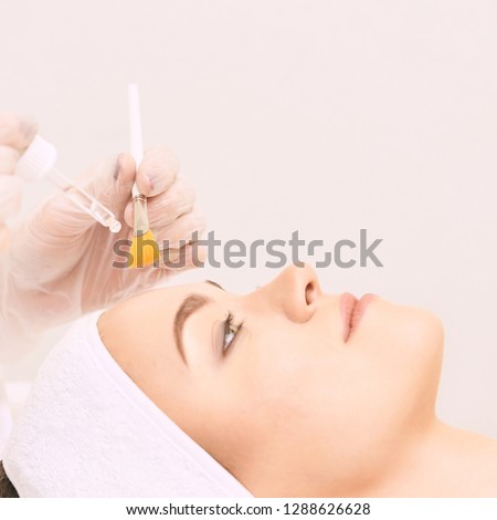 Young woman cleaning face skin in salon. Retinol peel with brush. Acid organic peeling. Royalty-Free Stock Photo #1288626628