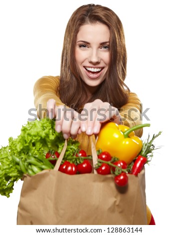 Portrait of happy young female holding a shopping bag full of groceries on white background