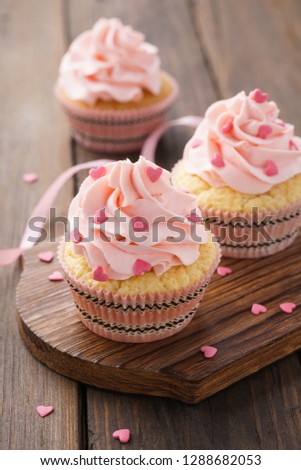 Pink Valentine's Day cupcakes decorated with heart shaped candy.