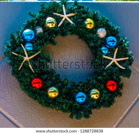 Christmas wreath with decorations isolated on a grey wall background