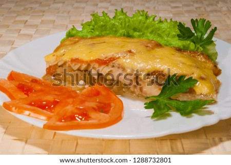 the sea fish baked under cheese with tomatoes and parsley