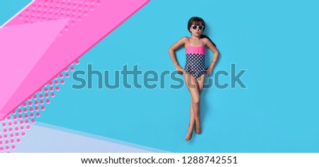 Fashion child summer. Little girl kid in swimsuit lay view top. Concept beach vacation. Blank, banner, copy space for ,advertising. Isolated pink, blue color background in studio.