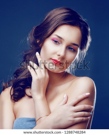 beautiful   young woman, against dark studio background