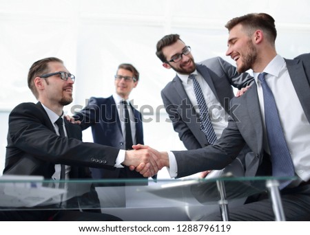 confident handshake business partners at the Desk